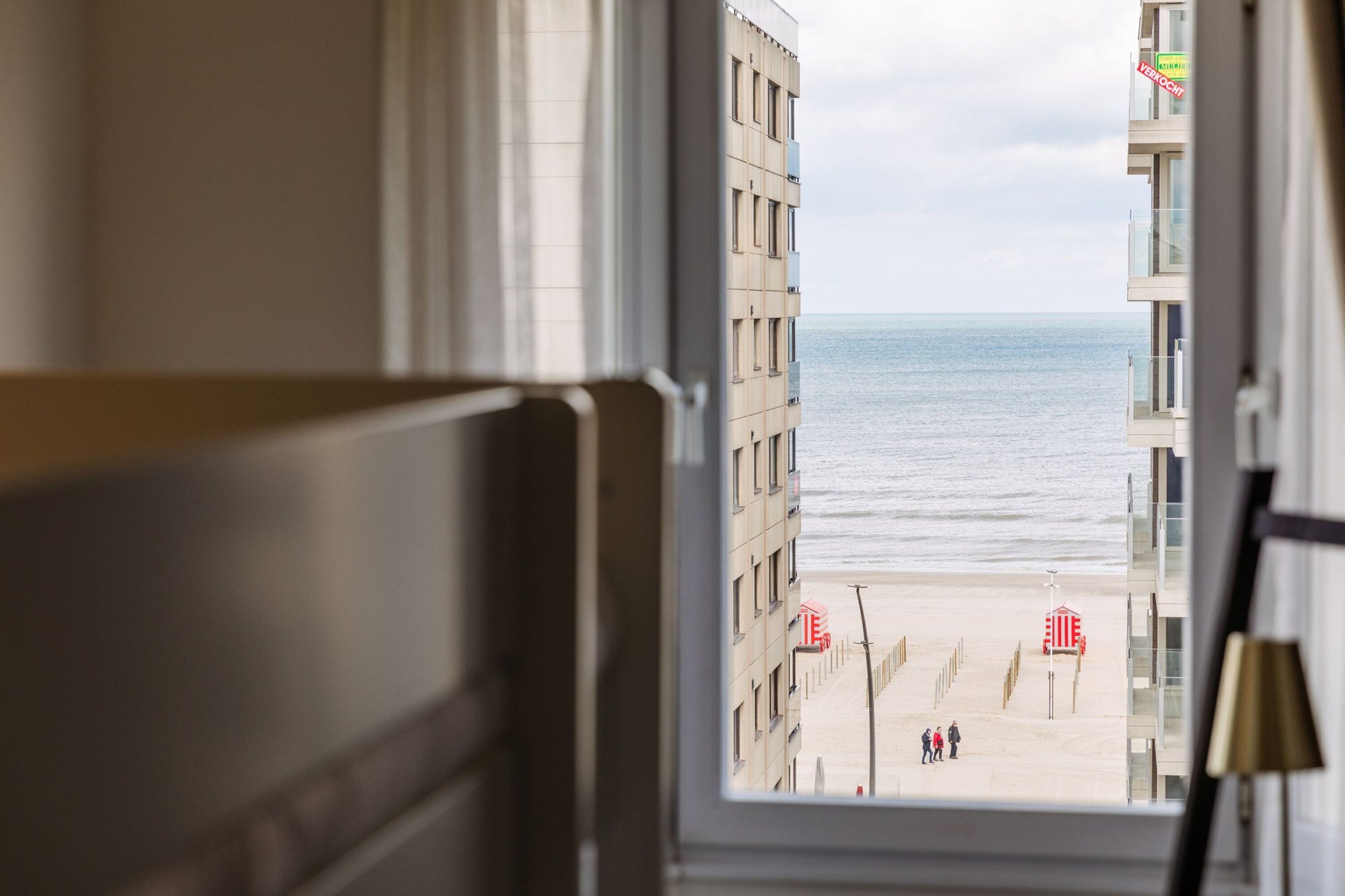 Blick aus einem Hotelzimmer auf Strand und Meer in De Panne